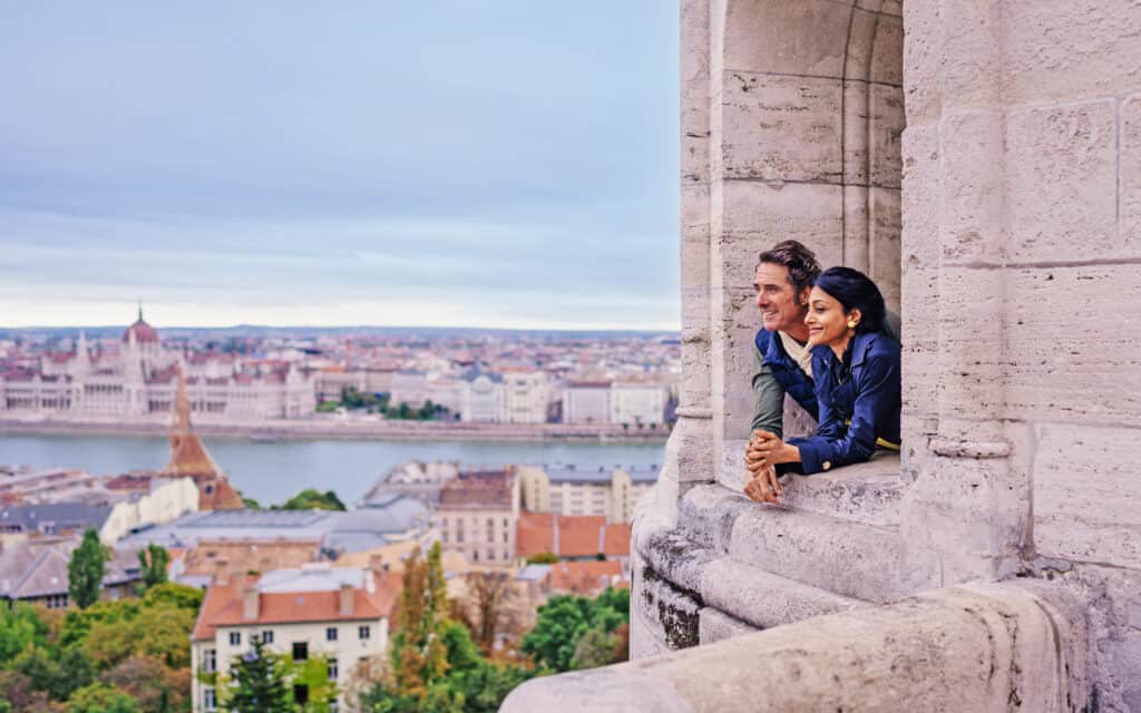 people leaning out of opening in historical building in Budapest while on a stop from an AmaWaterways river cruise