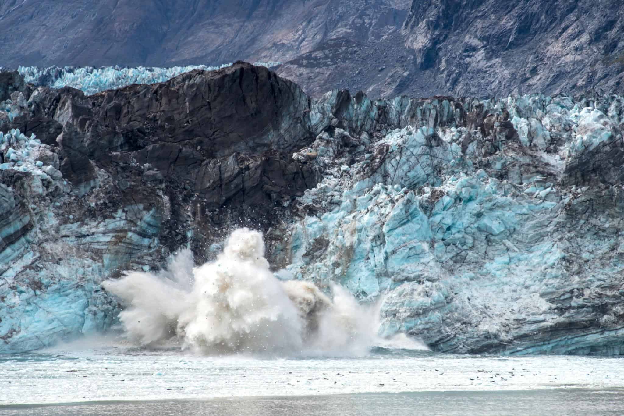Massive glacier calving into the ocean in Glacier Bay National Park during an Alaska cruise scenic sailing day.