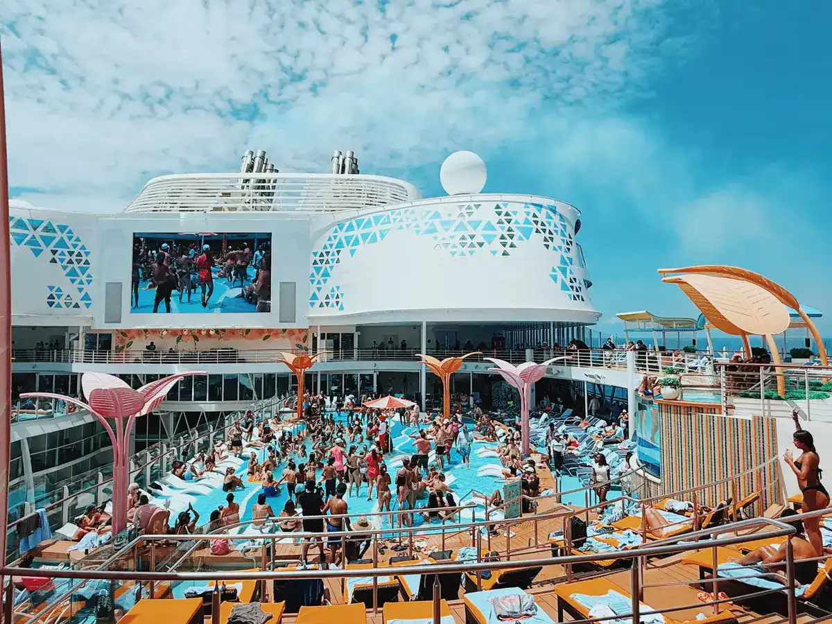Large cruise ship pool deck crowded with passengers water slides and entertainment