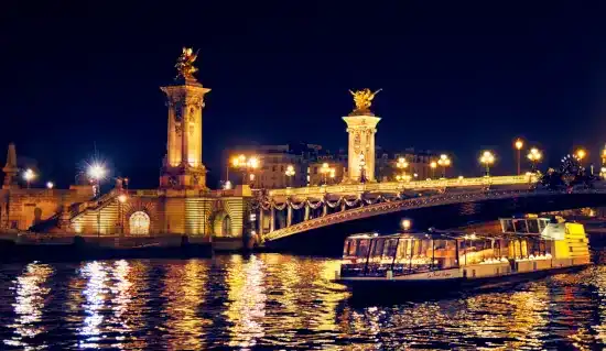 Luxury European river cruise evening on the Seine in Paris with illuminated bridges and a romantic dinner experience