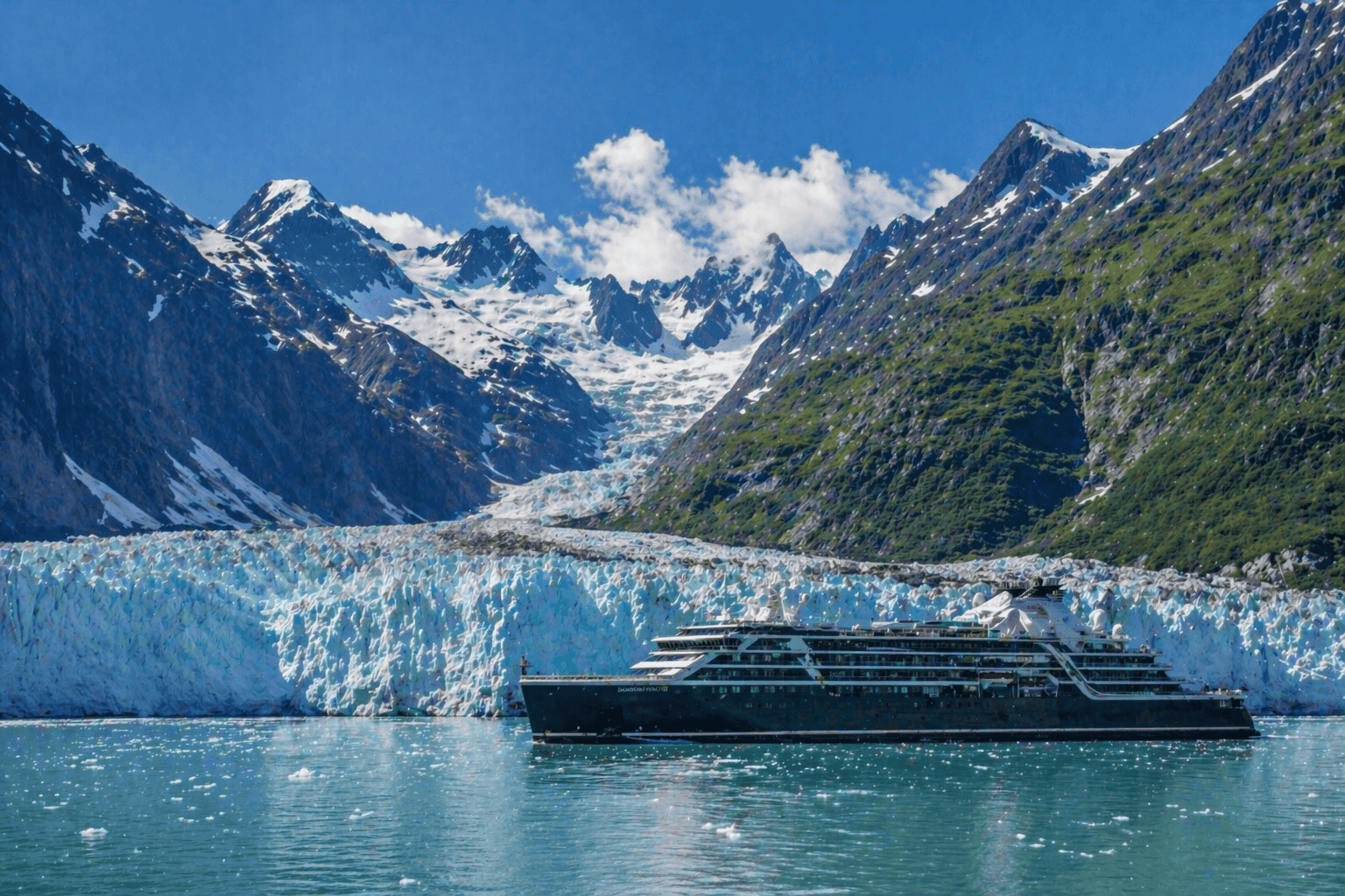 Cruise ship sailing past a glacier in Alaska's Inside Passage in summer.
