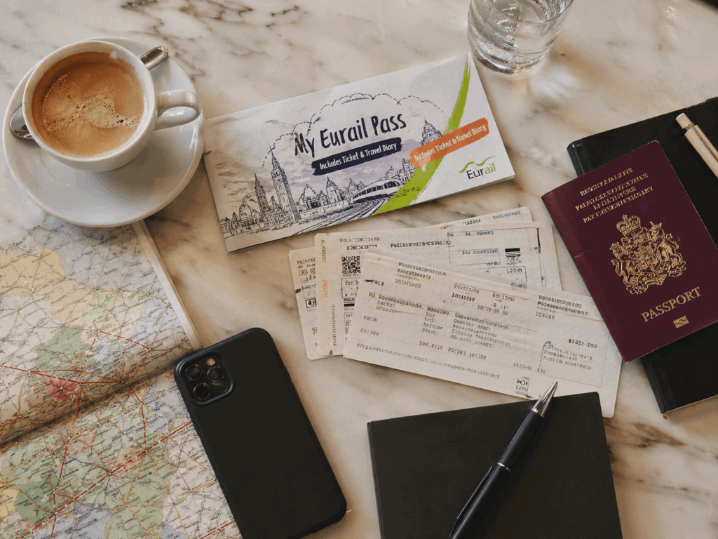 Interrail pass and passport on a station bench, illustrating European rail travel costs in 2026
