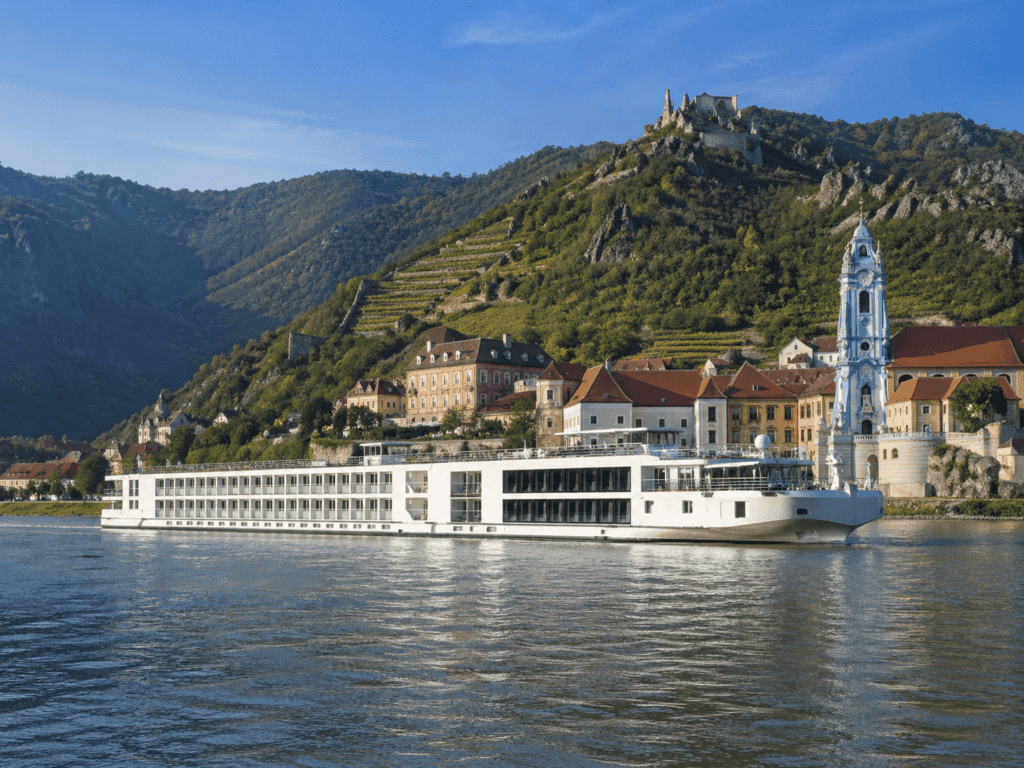 River cruise ship on the Danube passing a hilltop castle in Central Europe