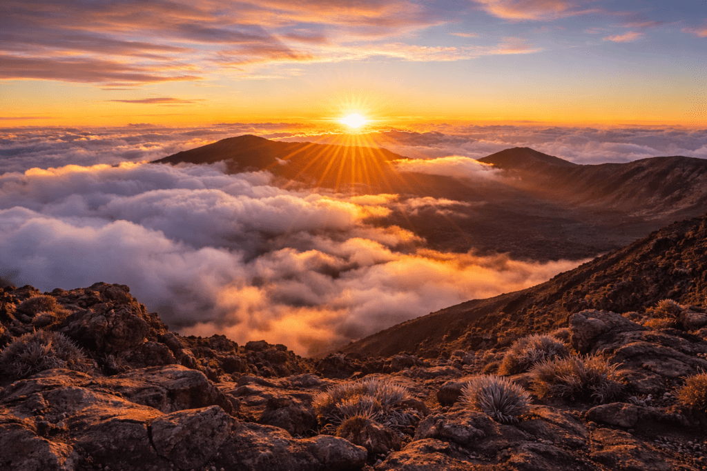 Golden sunrise above a sea of clouds at Haleakala volcano summit on Maui, Hawaii, viewed from 10,000 feet elevation