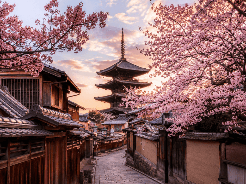 Cherry blossoms in full bloom over a traditional Japanese village, a top 2027 honeymoon destination.