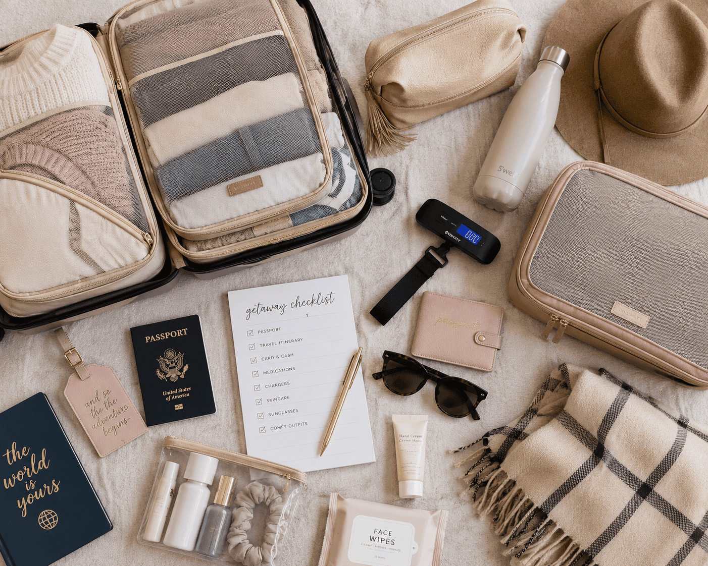 Flatlay of packing cubes, a luggage scale, and travel essentials for a fall girlfriend getaway