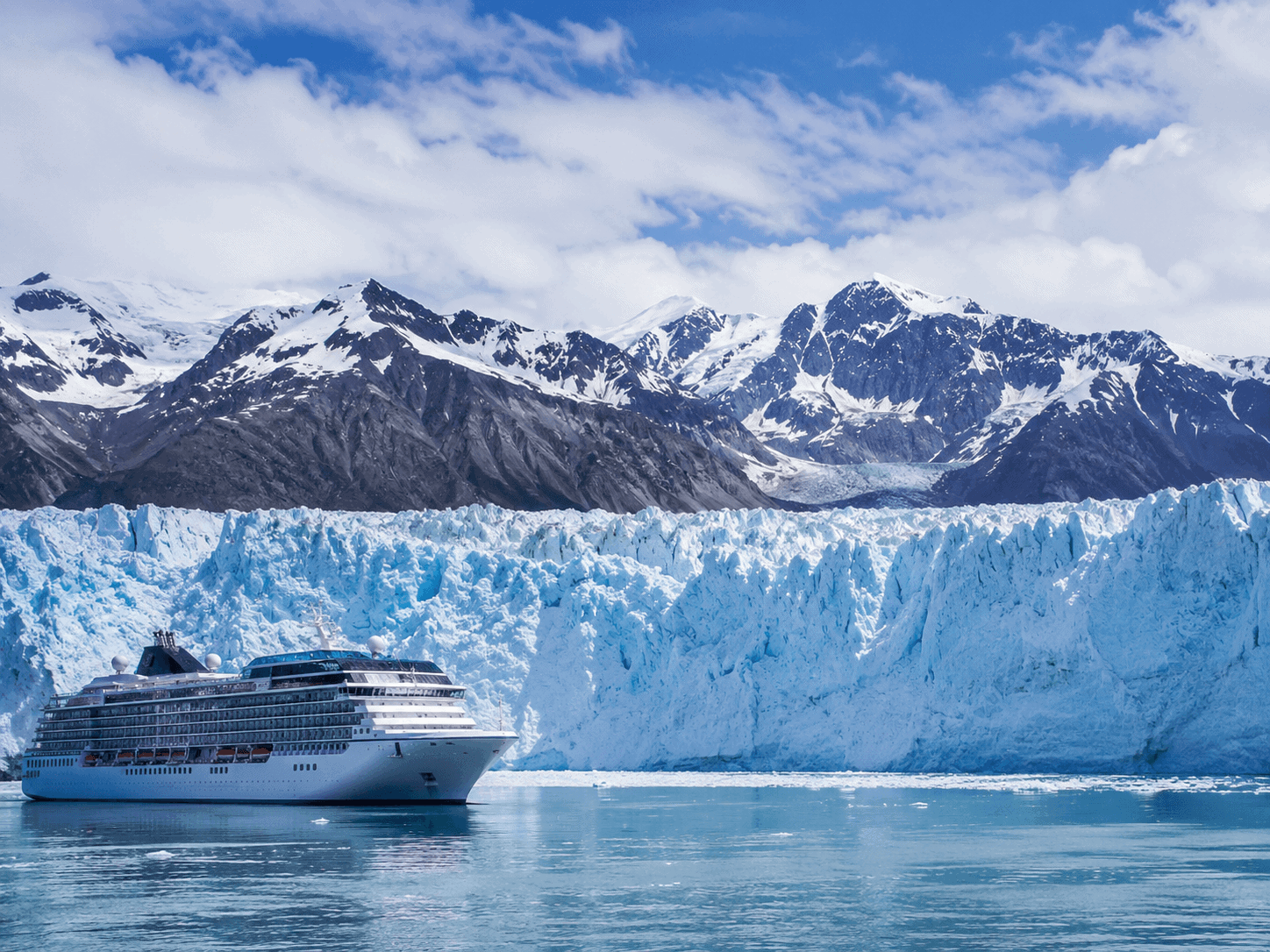 Cruise ship passing a glacier in Alaska, illustrating when to book a cruise for the 2027 Alaska season